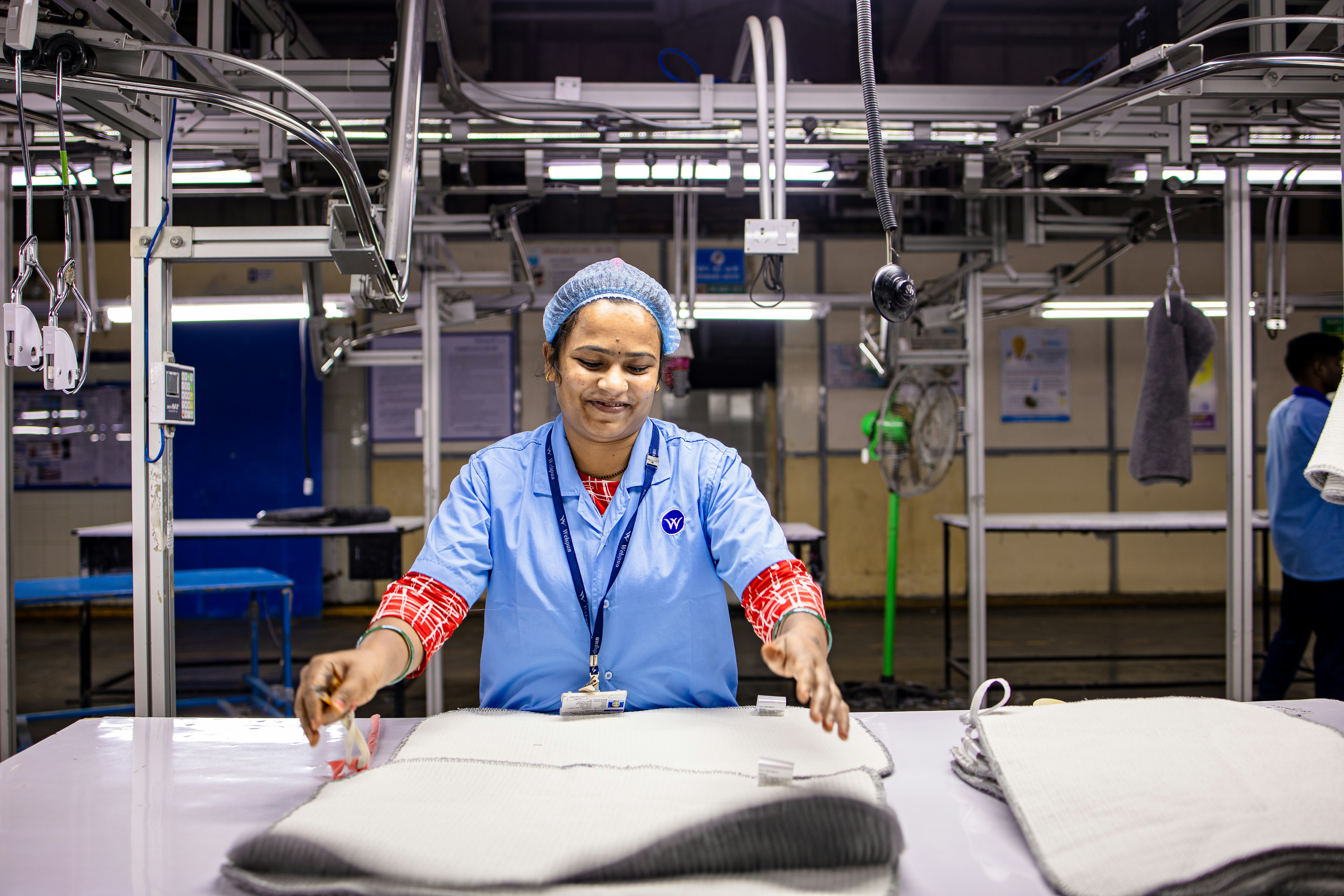 Professional quality control inspector checking fabric details in a high-tech facility